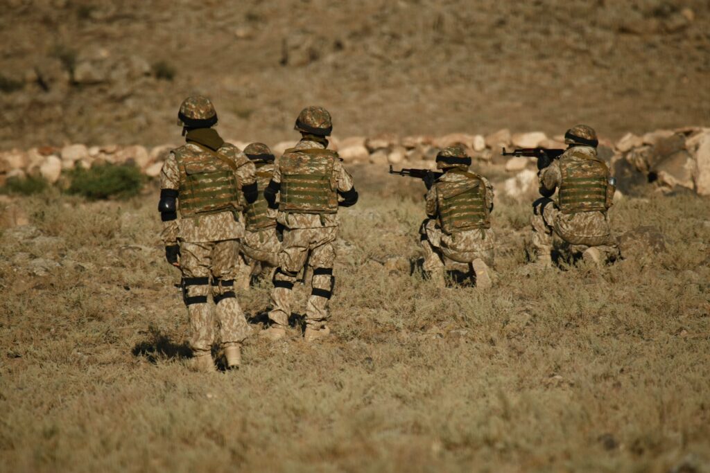 A shot of Armenian military soldiers training in a dry field